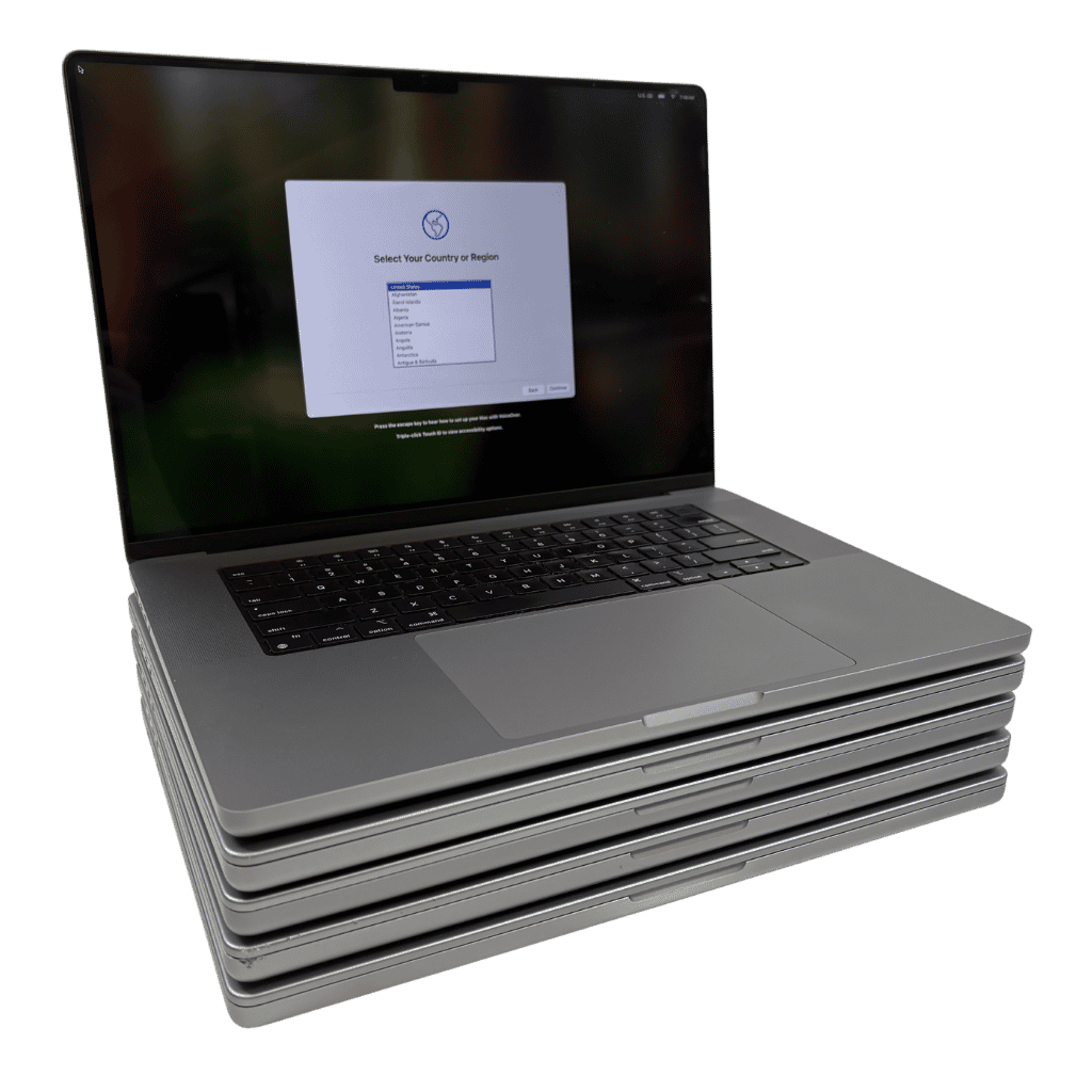 Five silver laptops stacked, the top one open and showing a setup screen.